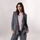A model wearing seasonal grey hooded blazer - عارضة أزياء ترتدي سترة رمادية بغطاء رأس