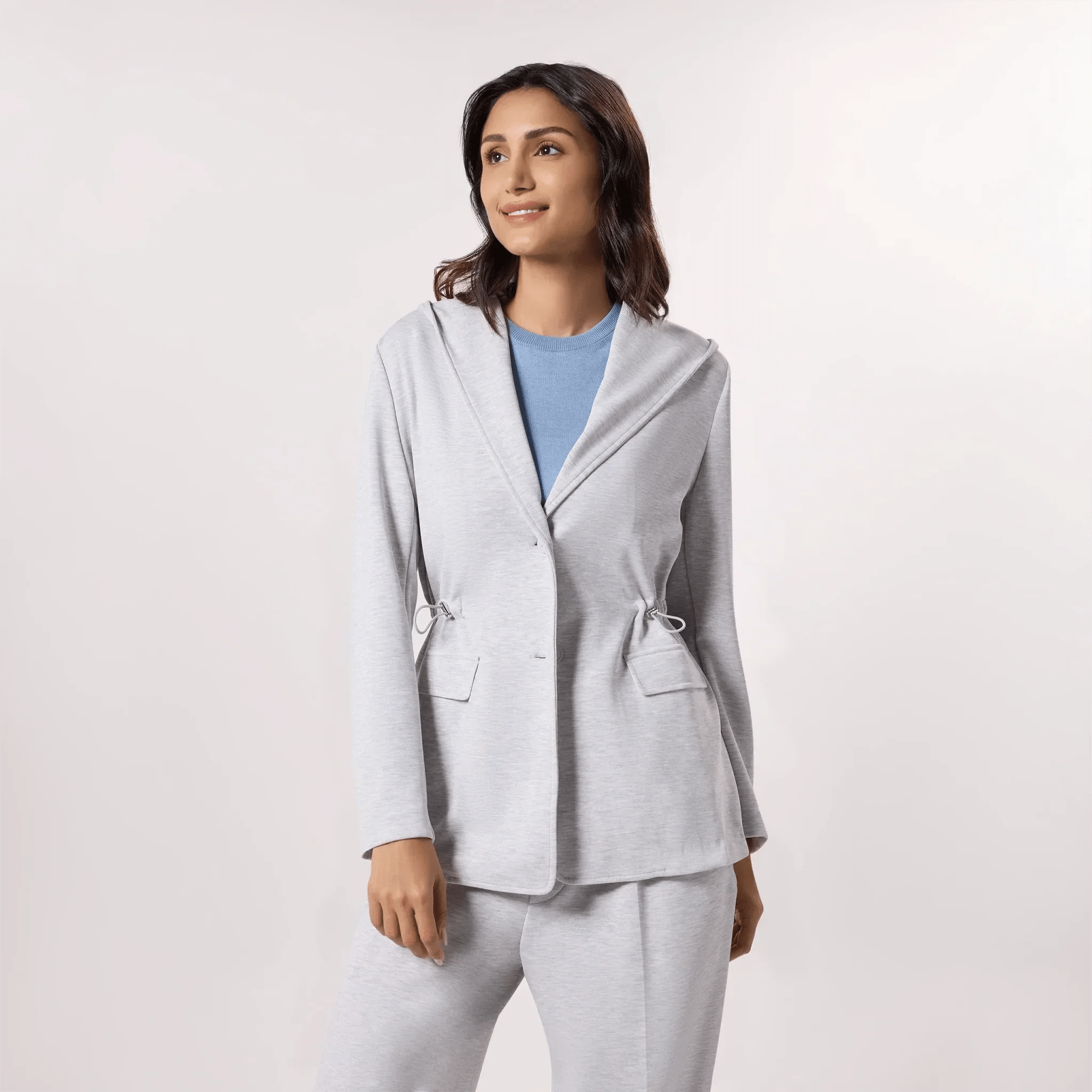 A model wearing seasonal grey hooded blazer with matching pants - عارضة أزياء ترتدي هودي رمادي مع بنطال متناسق