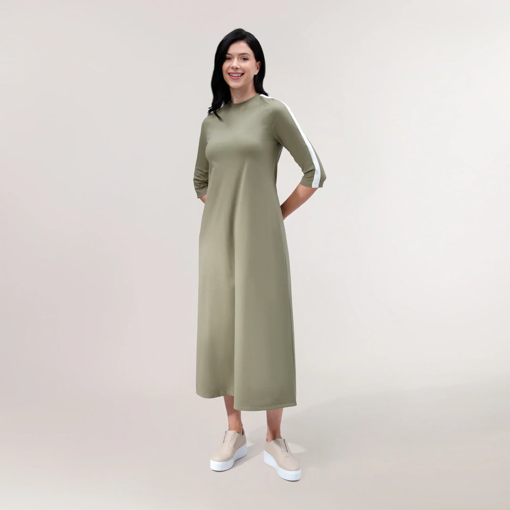 A model wearing flared maxi dress in a seasonal rainforest green color - عارضة أزياء ترتدي فستان ماكسي واسع باللون الأخضر