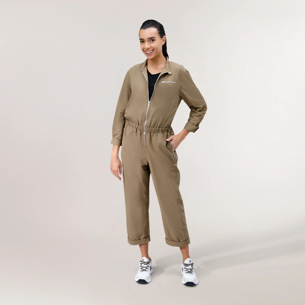 ِA model wearing beige parachute jumpsuit with relaxed fit - عارضة أزياء ترتدي جمبسوت باراشوت باللون البيج بقصّة مريحة