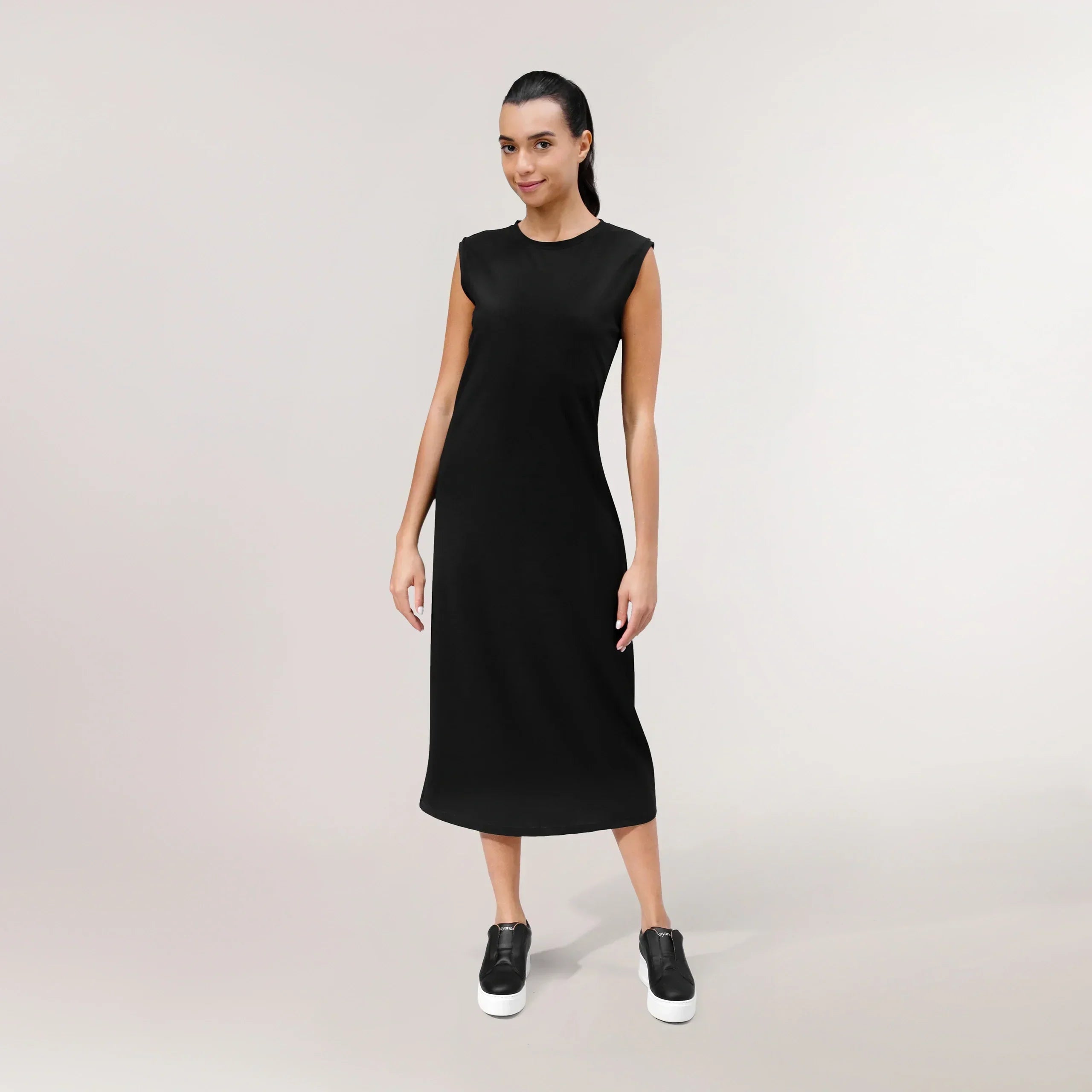 A model wearing seasonal black sleeveless dress - عارضة أزياء ترتدي فستانًا أسودًا بدون أكمام