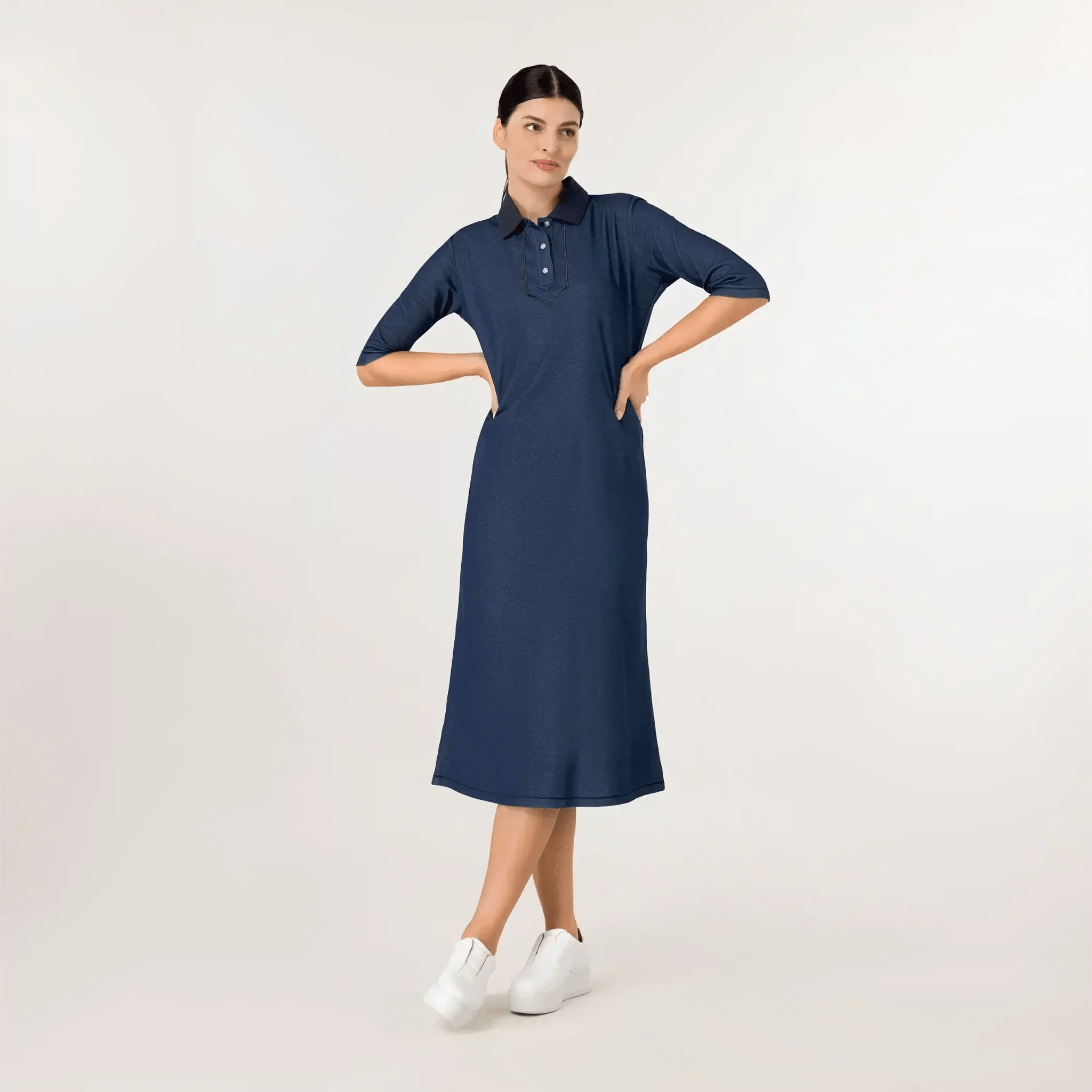 A model wearing knee covering polo dress in a seasonal navy color - عارضة أزياء ترتدي فستان بولو يغطي الركبة باللون الأزرق البحري
