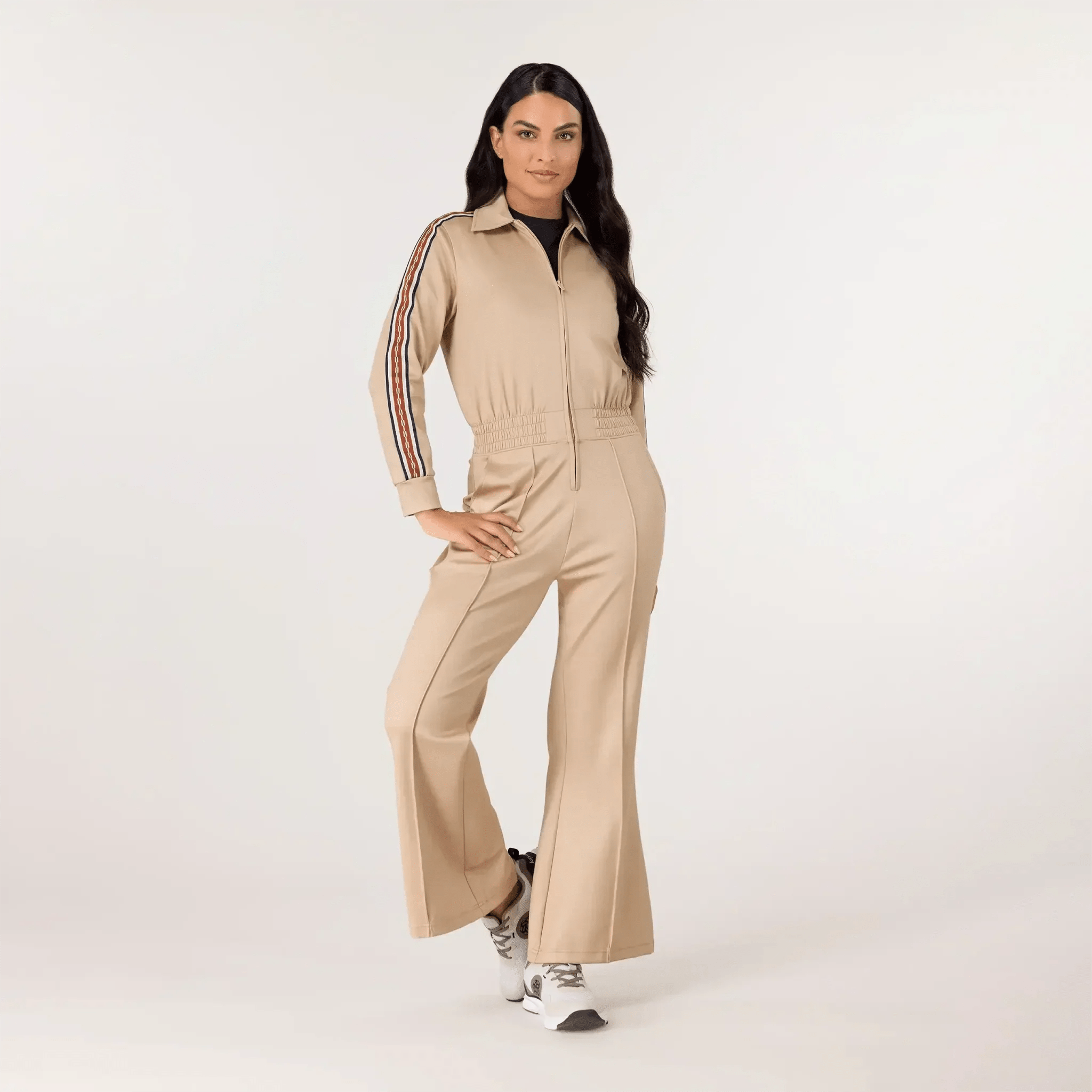 A model wearing seasonal sand track jumpsuit - عارضة أزياء ترتدي جمبسوت رياضي باللون الرملي