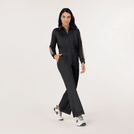 A model wearing black font zip track jumpsuit - عارضة أزياء ترتدي بذلة رياضية سوداء بسحاب