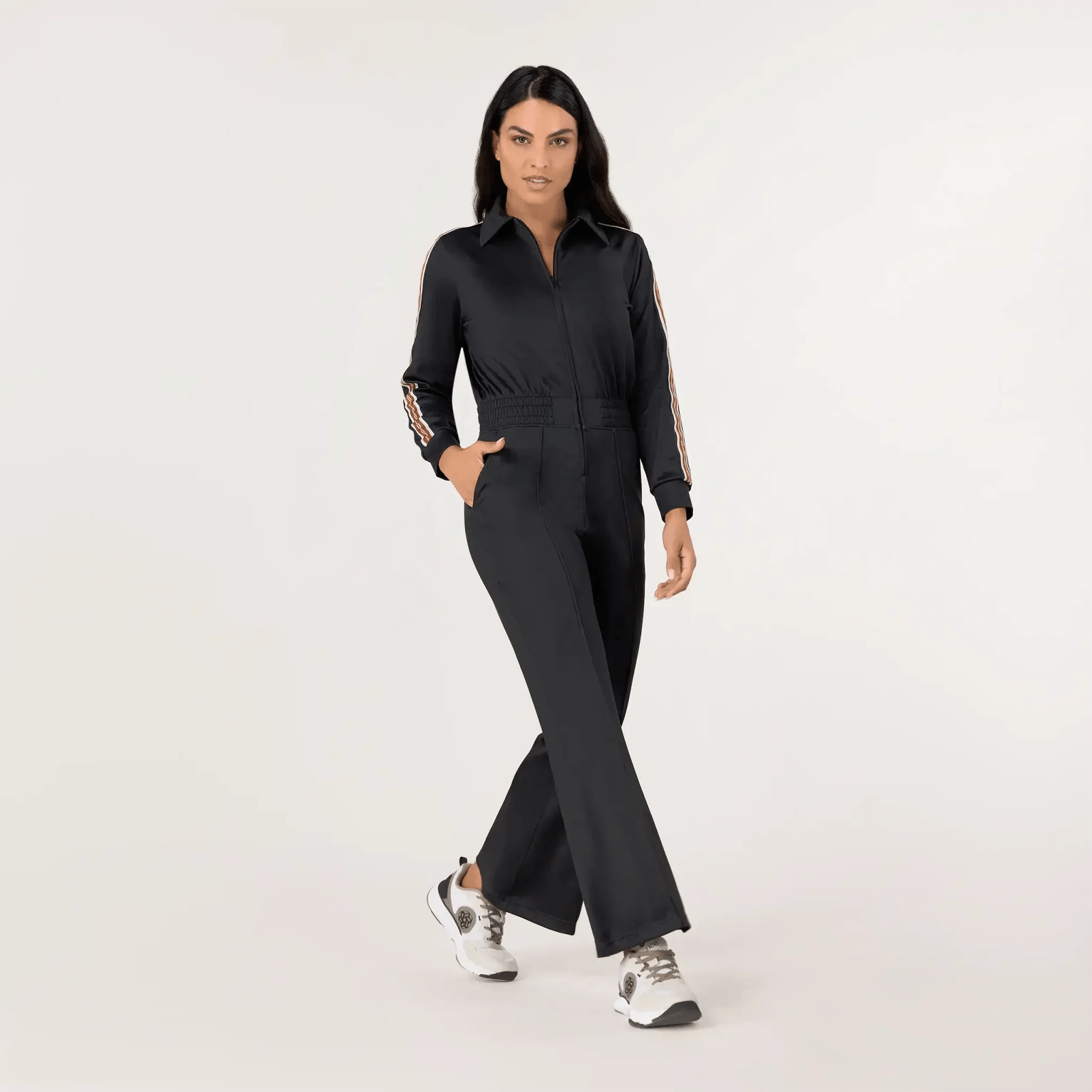 A model wearing black font zip track jumpsuit - عارضة أزياء ترتدي بذلة رياضية سوداء بسحاب