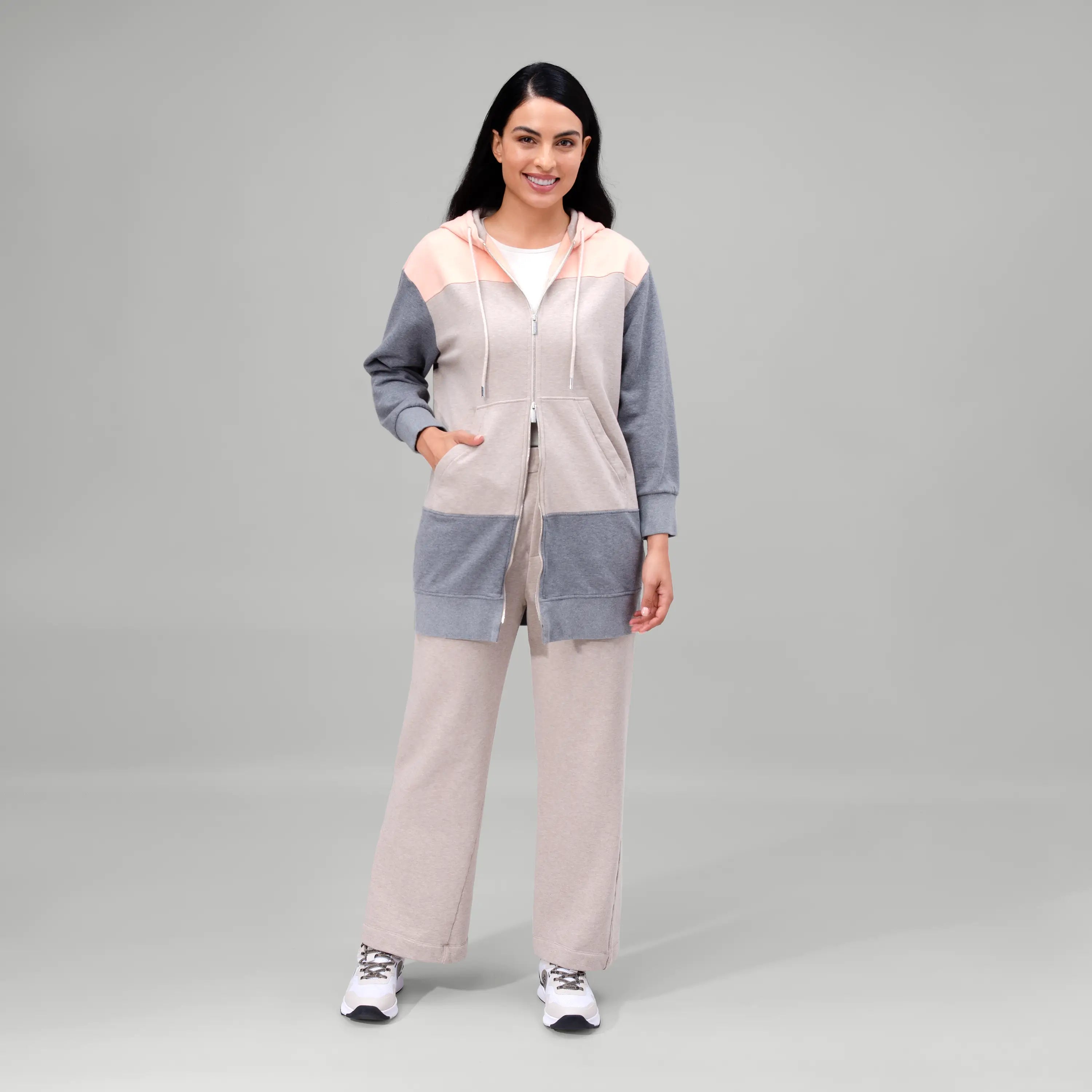 Oatmeal melange zip front hoodie with soft fabric & relaxed fit - عارضة أزياء ترتدي هودي بسحاب أمامي بلون الشوفان الممزوج بقماش ناعم وقصّة مريحة