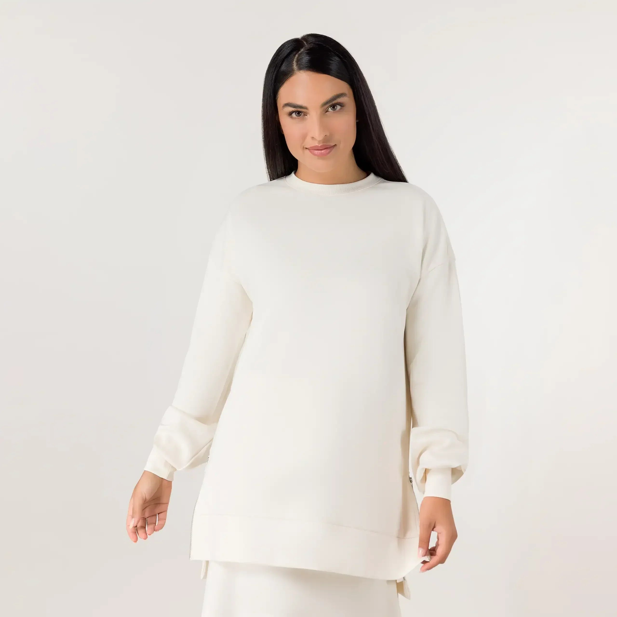 A model wearing seasonal beige soft tunic pullover - عارضة أزياء ترتدي سترة تونيك ناعمة باللون البيج