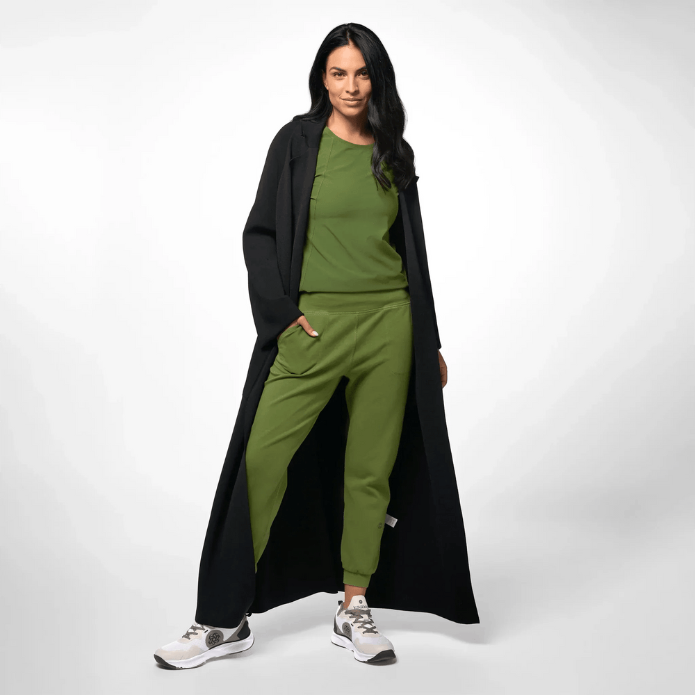 A model wearing seasonal black maxi knitted coat over a green set - عارضة أزياء ترتدي معطف طويل محبوك باللون الأسود فوق طقم أخضر