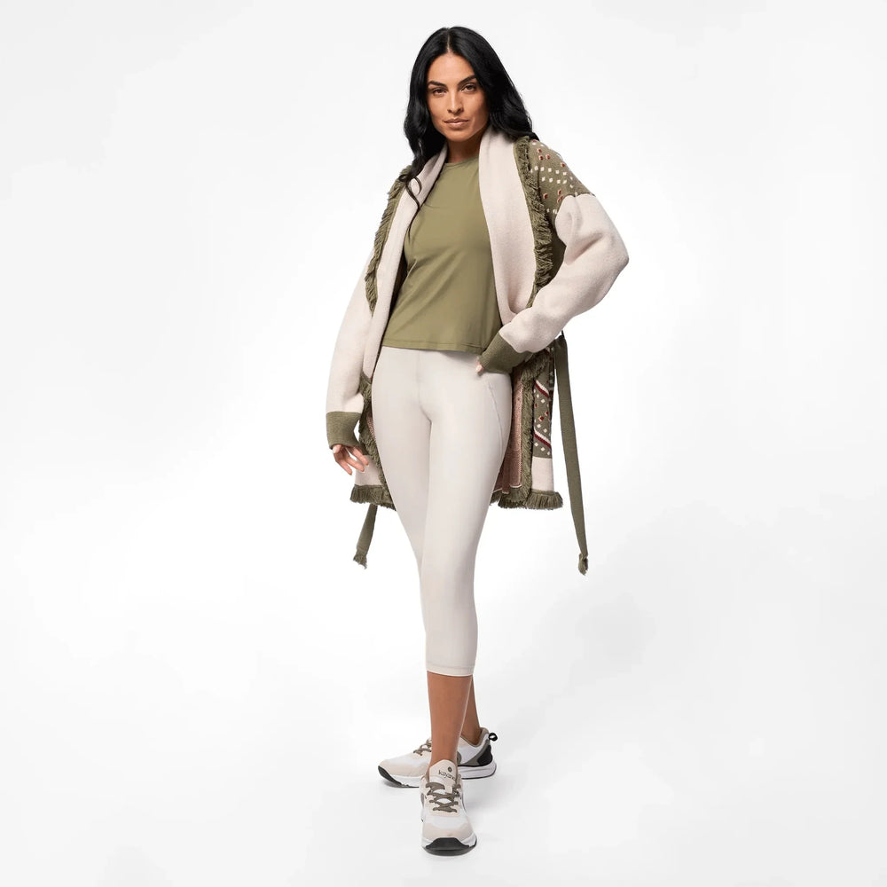 A model wearing seasonal green heritage midi wrap cardigan over sports set - عارضة أزياء ترتدي سترة متوسطة الطول باللون الأخضر فوق طقم رياضي