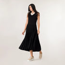 A model wearing a sleeveless pleated knit dress in a seasonal black color - عارضة أزياء ترتدي فستان أسود محبوك بدون أكمام