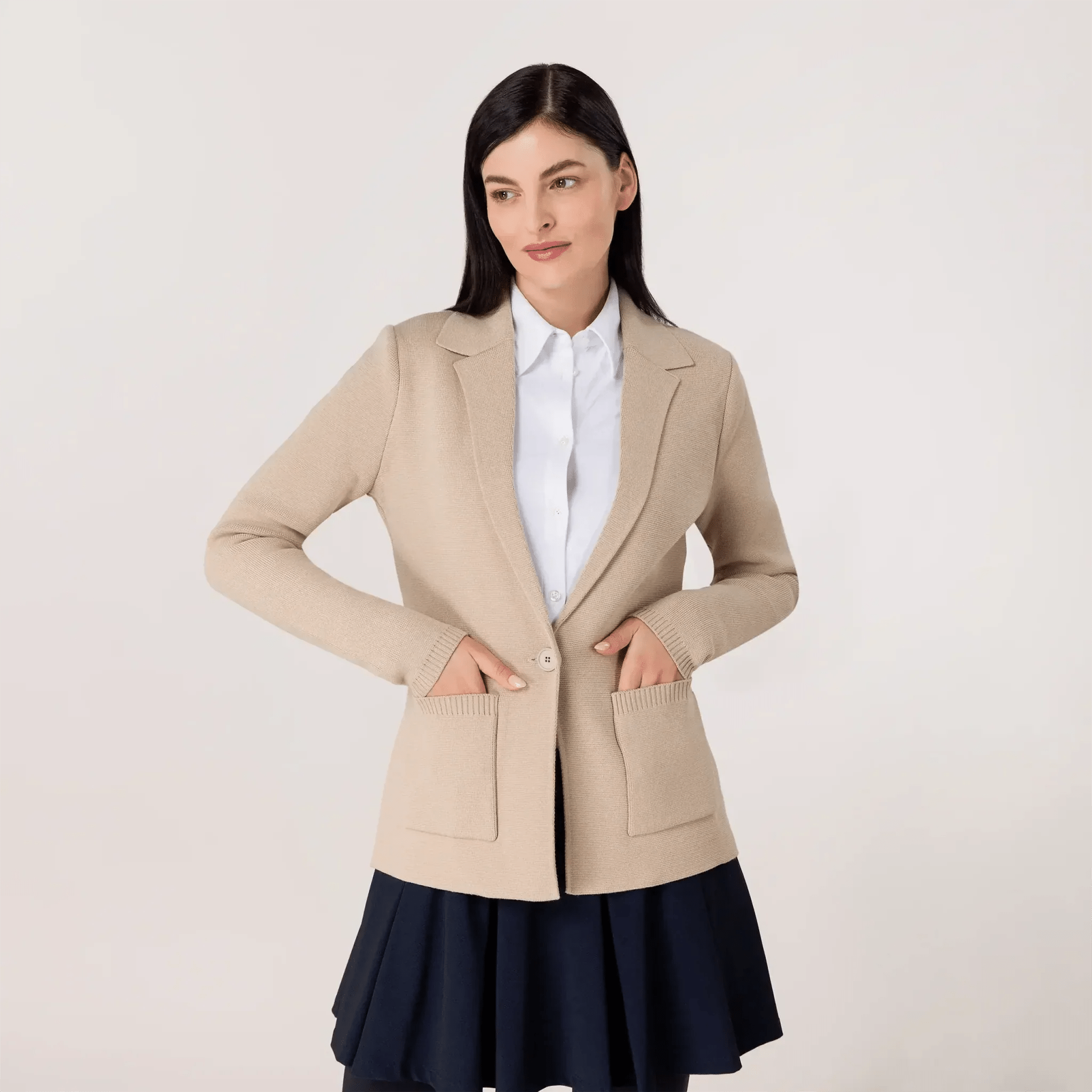 A model wearing beige knitted collared blazer with side pockets - عارضة أزياء ترتدي سترة بيج محبوكة ذات ياقة و جيوب جانبية
