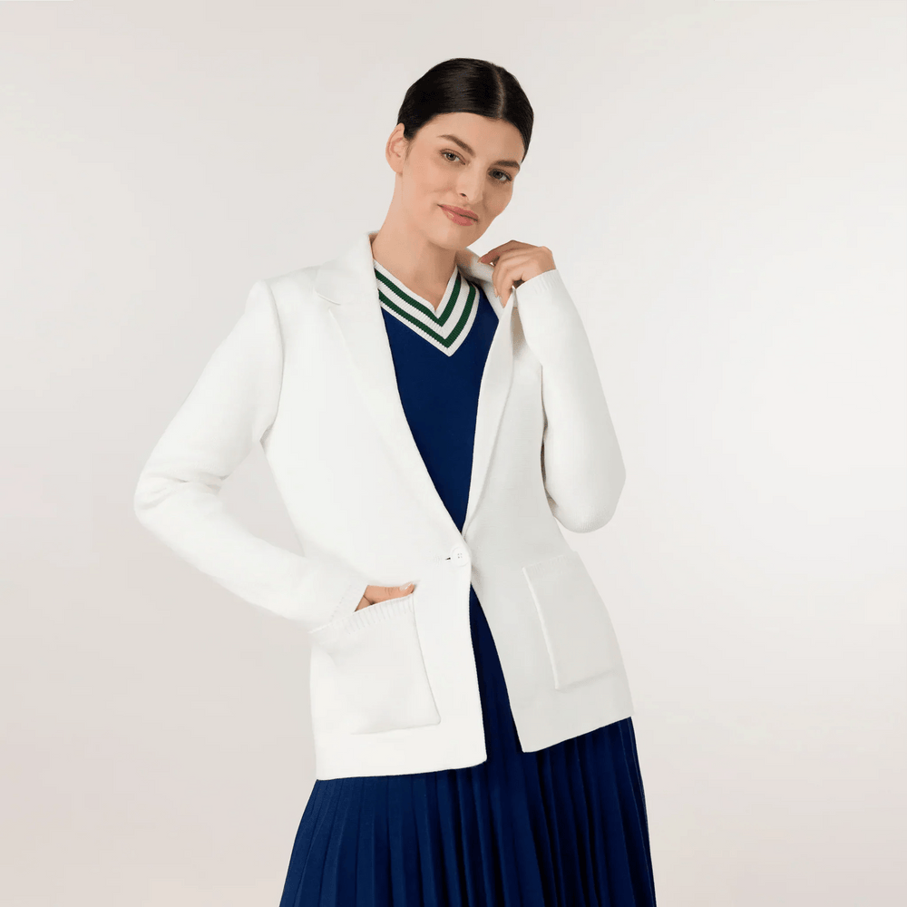 A model wearing seasonal white knitted blazer over blue dress - عارضة أزياء ترتدي سترة بيضاء محبوكة فوق فستان أزرق