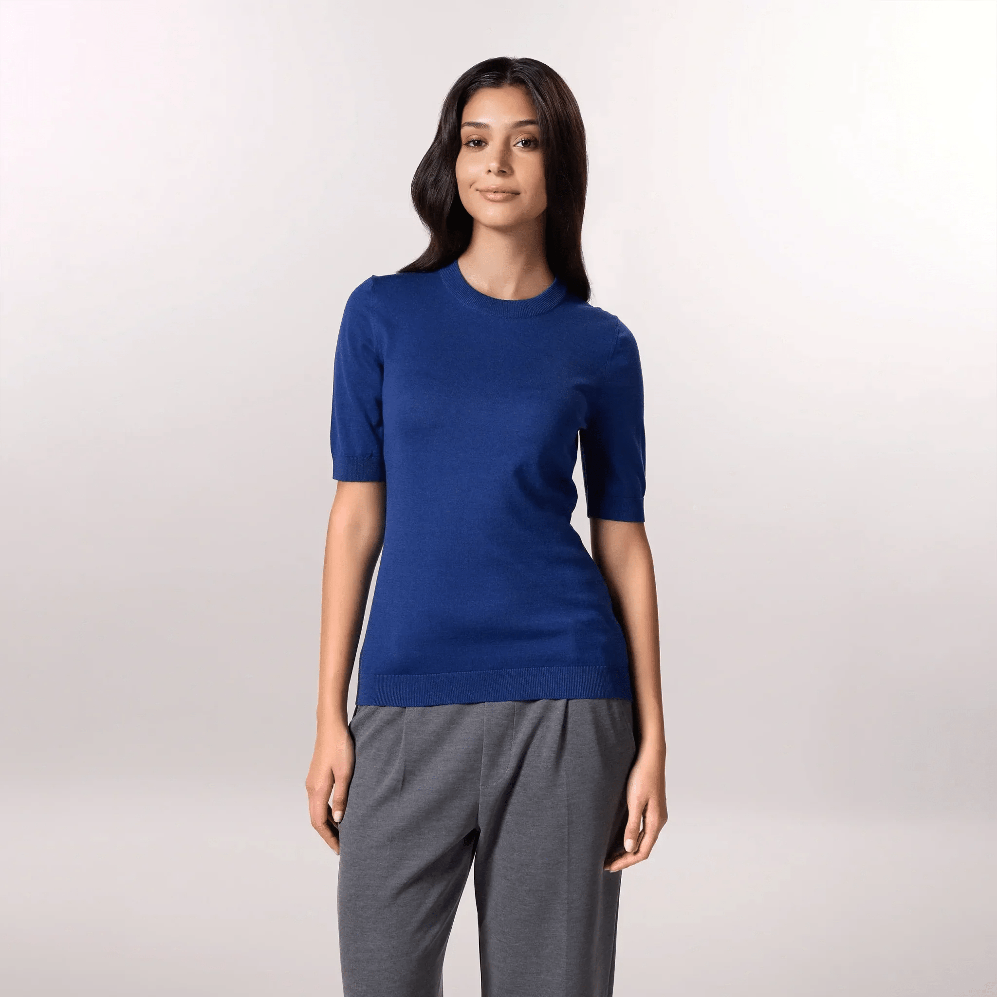 A model wearing a seasonal blue half sleeved knit sweater - عارضة أزياء ترتدي سترة باللون الأزرق قصيرة الأكمام