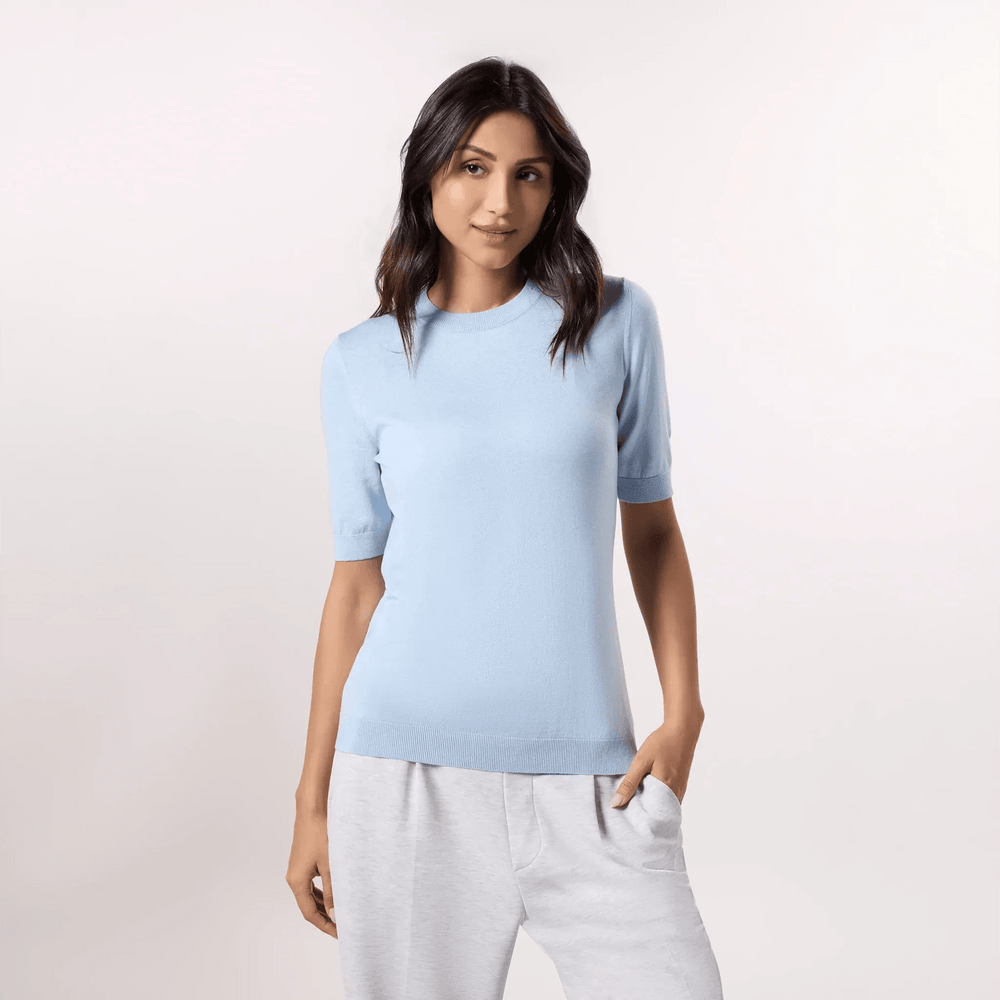 A model wearing a half sleeve knit sweater in a light blue color - عارضة أزياء ترتدي سترة محبوكة نصف كم باللون الأزرق الفاتح