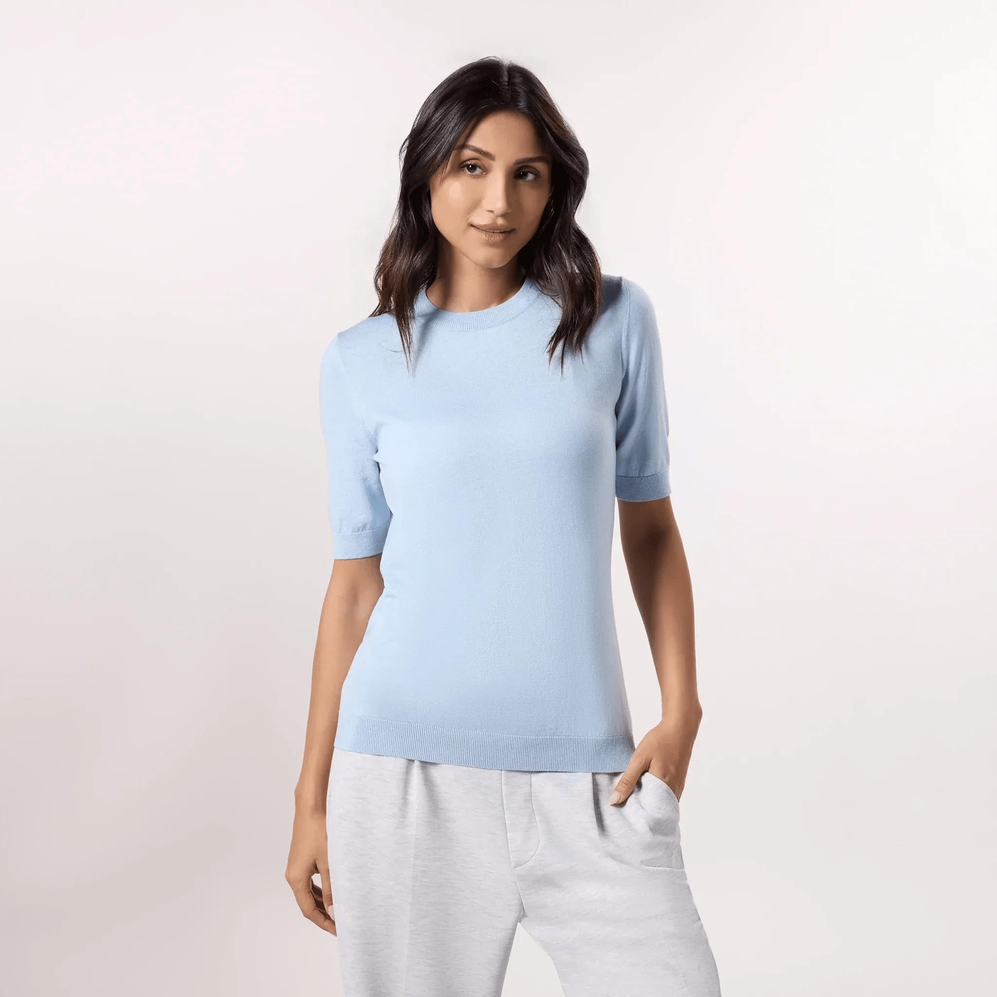 A model wearing a half sleeve knit sweater in a light blue color - عارضة أزياء ترتدي سترة محبوكة نصف كم باللون الأزرق الفاتح