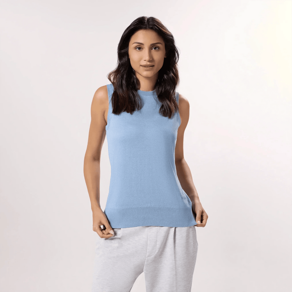 A model wearing seasonal light blue knitted sleeveless sweater - عارضة أزياء ترتدي سترة زرقاء فاتحة اللون بدون أكمام
