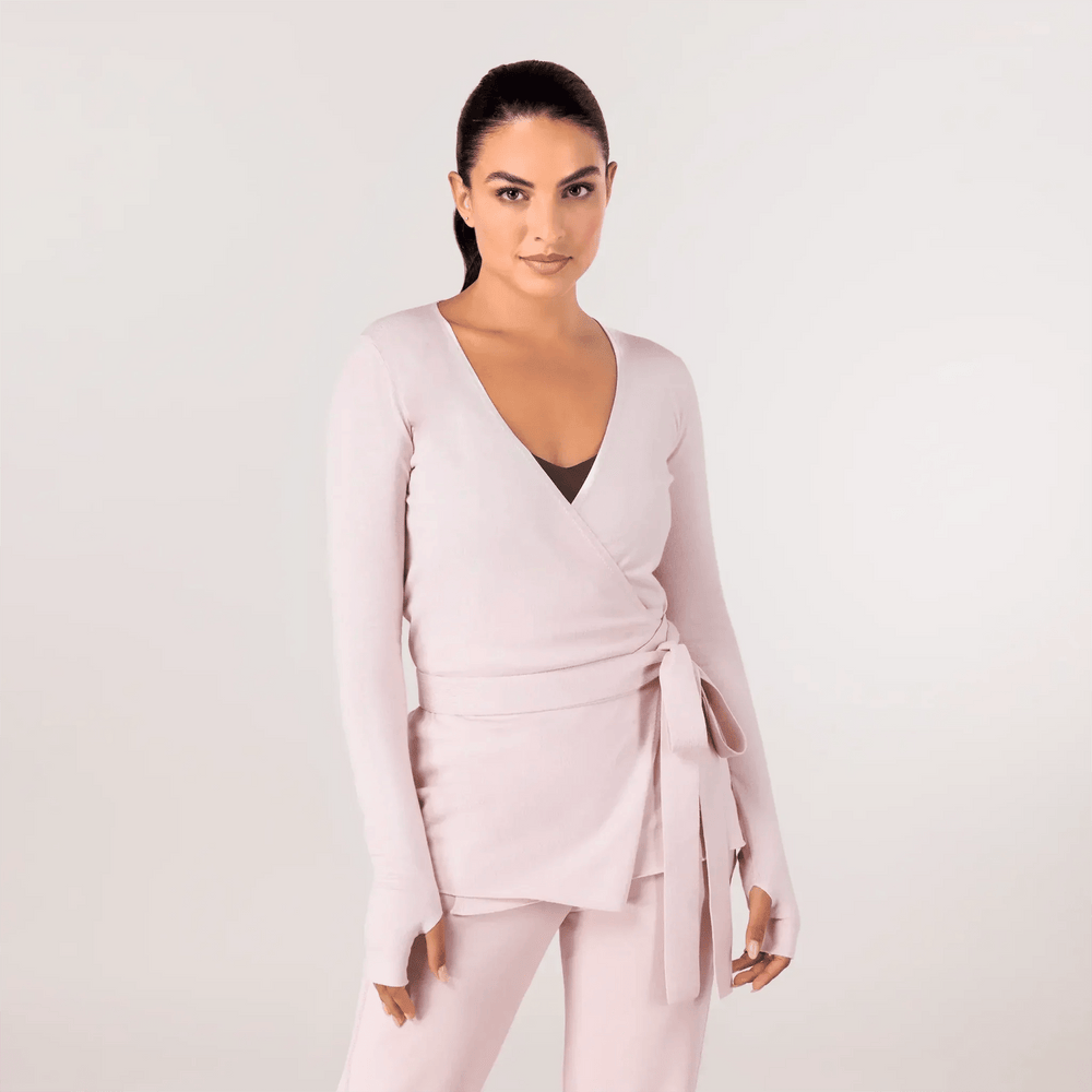 A model wearing a core light pink wrap sweater - عارضة أزياء ترتدي سترة ملفوفة باللون الوردي الفاتح