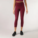 A model wearing grape red compression crop leggings with sculpting fit - عارضة أزياء ترتدي ليغينغ ضاغط قصير باللون الأحمر العنابي بقصة تنحت القوام