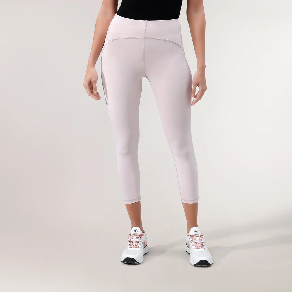 A model wearing Freestyle light pink cropped leggings with a high-waisted fit - عارضة أزياء ترتدي ليقنز "فري ستايل" قصير باللون وردي فاتح بقصة خصر عالية