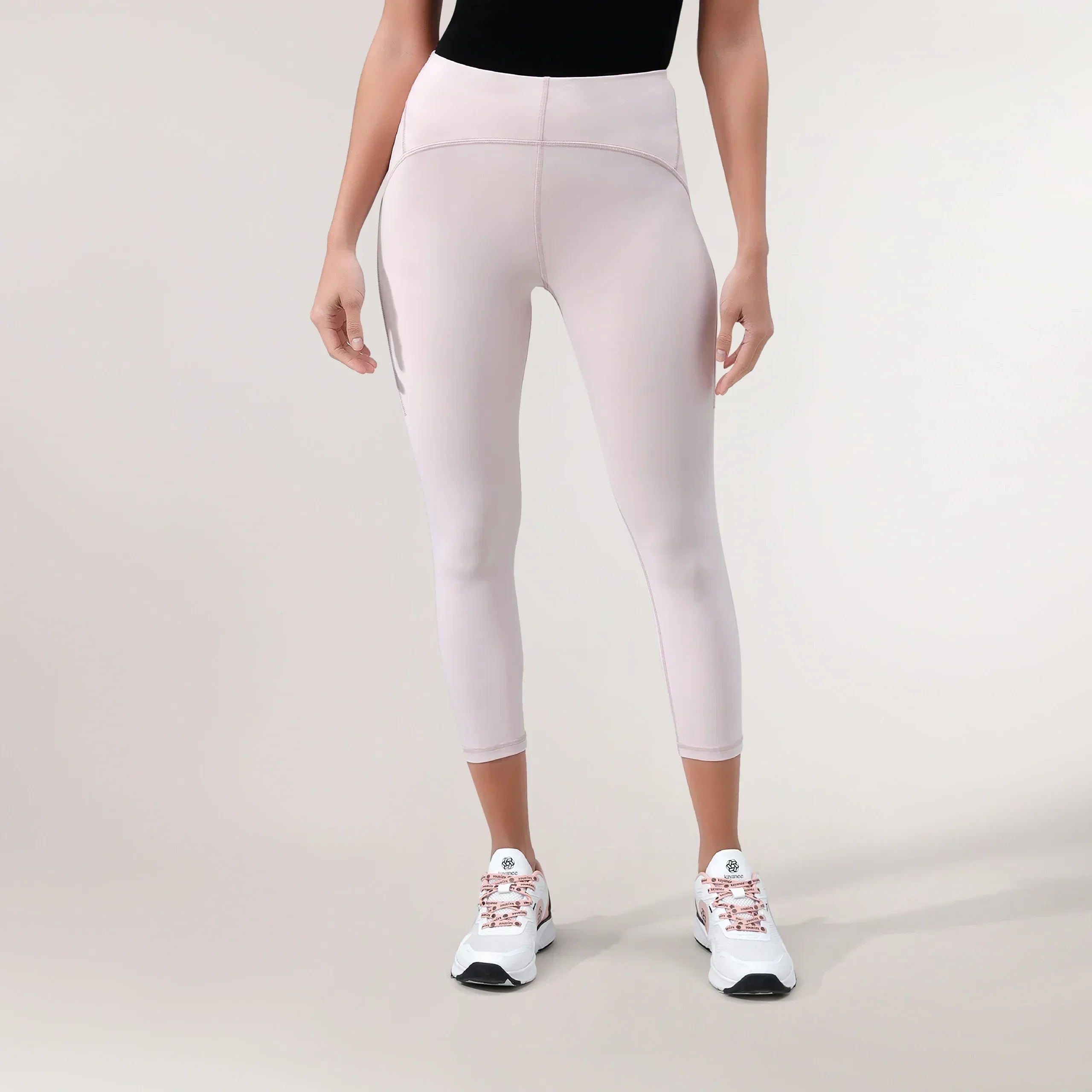 A model wearing Freestyle light pink cropped leggings with a high-waisted fit - عارضة أزياء ترتدي ليقنز "فري ستايل" قصير باللون وردي فاتح بقصة خصر عالية