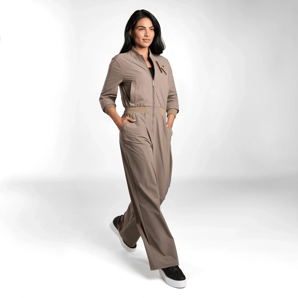 A model wearing a seasonal olive utility jumpsuit with pockets - عارضة أزياء ترتدي جمبسوت باللون الأخضر الزيتوني مع جيوب