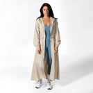 A model wearing a seasonal stone color hooded parka over a teal jumpsuit - عارضة أزياء ترتدي سترة باركا باللون الحجري بغطاء رأس فوق جمبسوت أزرق مخضر