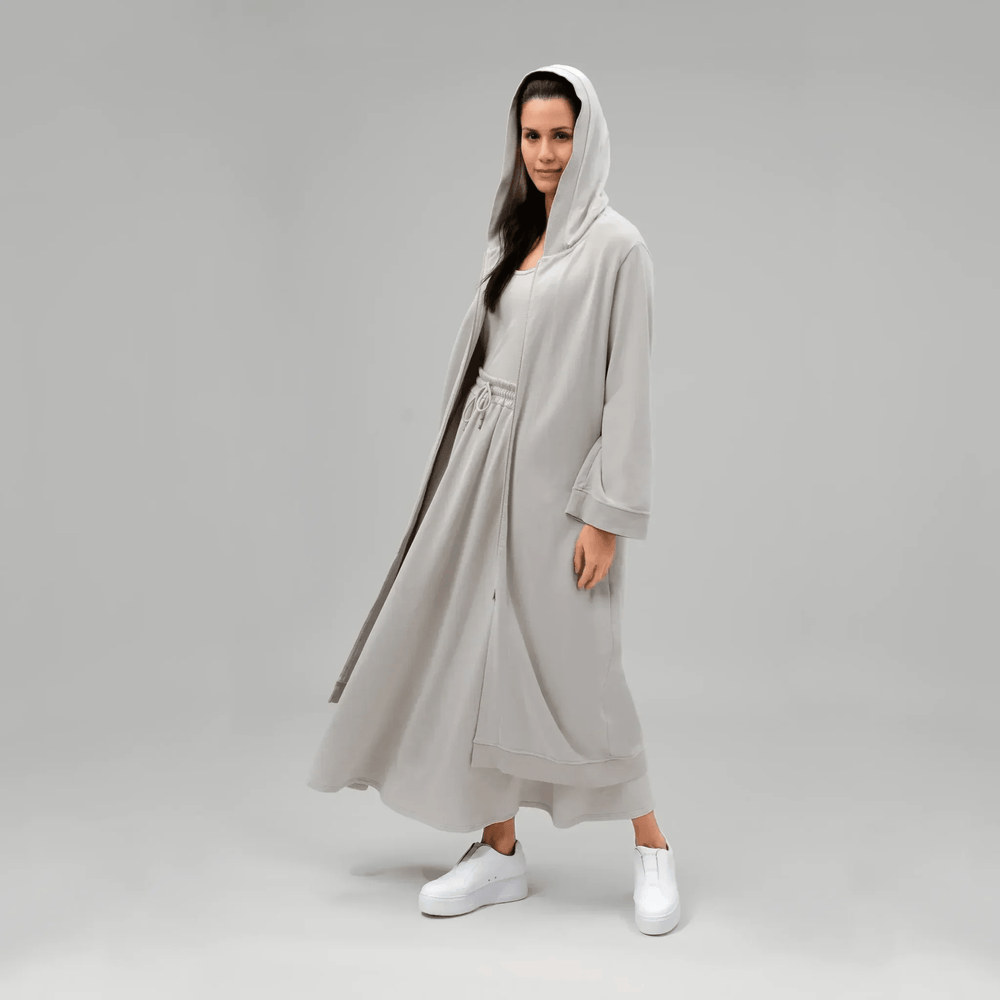 A model wearing core stone hooded good to go abaya - عارضة أزياء ترتدي عباءة بغطاء رأس باللون الحجري
