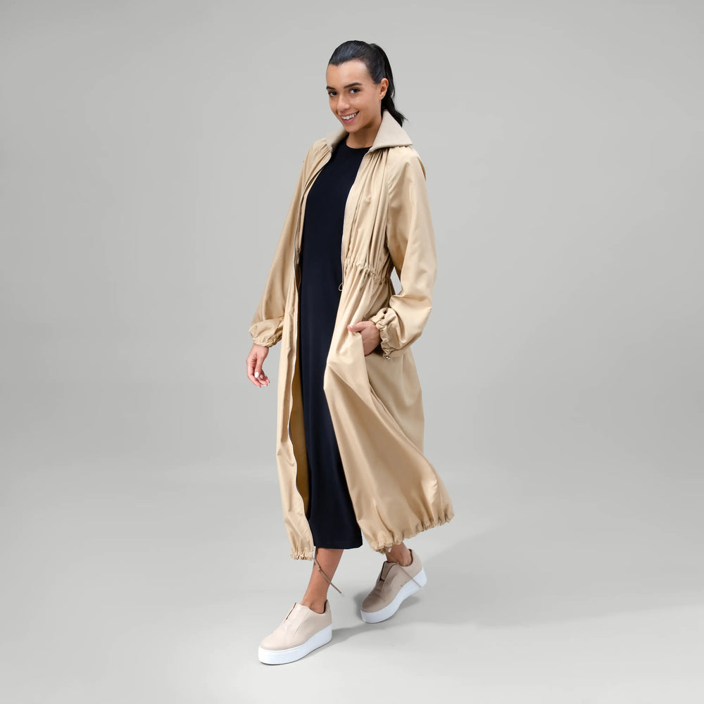 Sand zip front parka with utility pockets & longline fit - عارضة أزياء ترتدي باركا بسحاب أمامي باللون الرملي مع جيوب عملية وتصميم طويل