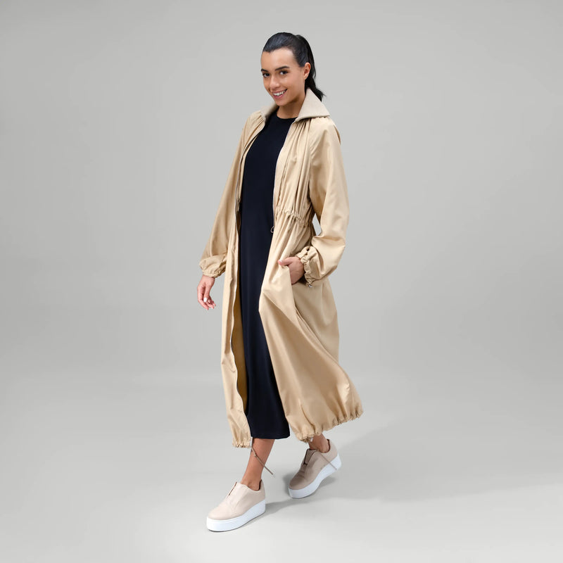 Sand zip front parka with utility pockets & longline fit - عارضة أزياء ترتدي باركا بسحاب أمامي باللون الرملي مع جيوب عملية وتصميم طويل