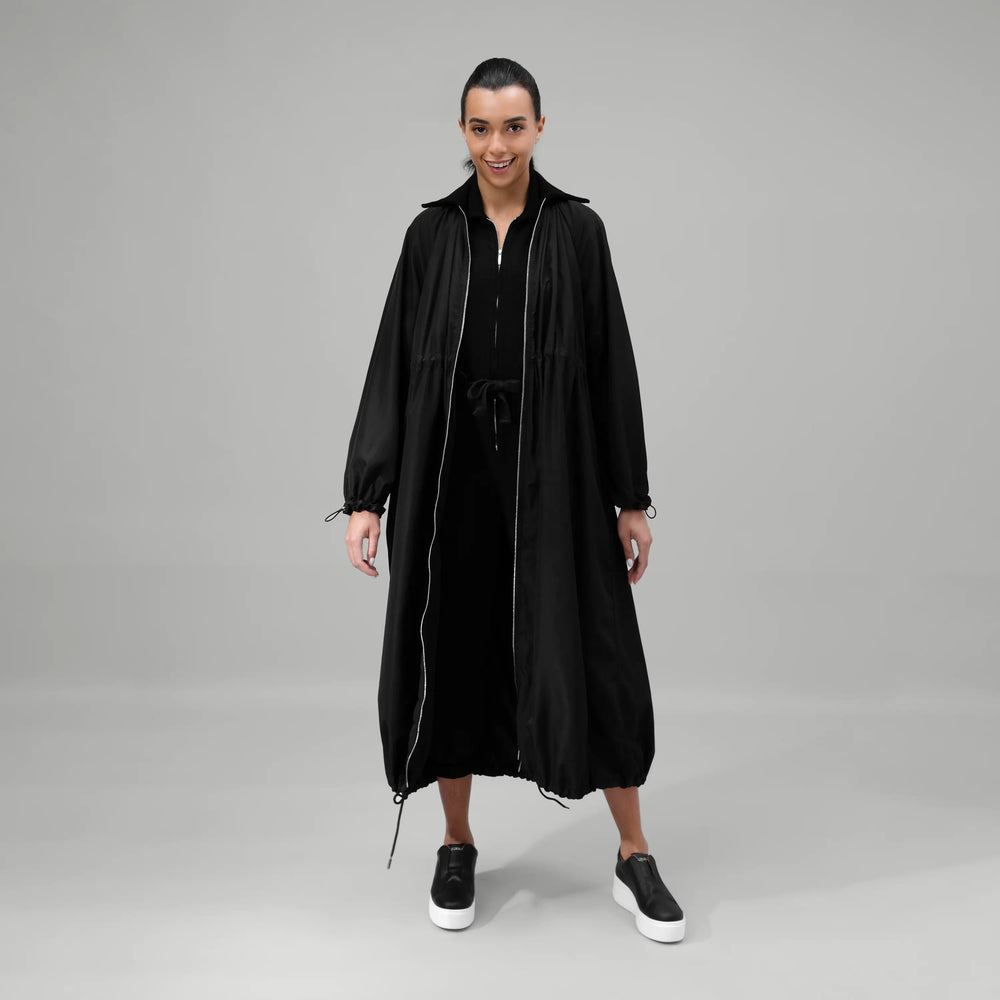 Black zip front parka with longline silhouette & adjustable hood - عارضة أزياء ترتدي باركا أسود طويل بسحاب أمامي وغطاء رأس قابل للتعديل