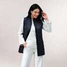 Black quilted vest with sleeveless design & padded finish - عارضة أزياء ترتدي سترة مبطّنة بدون أكمام باللون الأسود ولمسة مبطنة