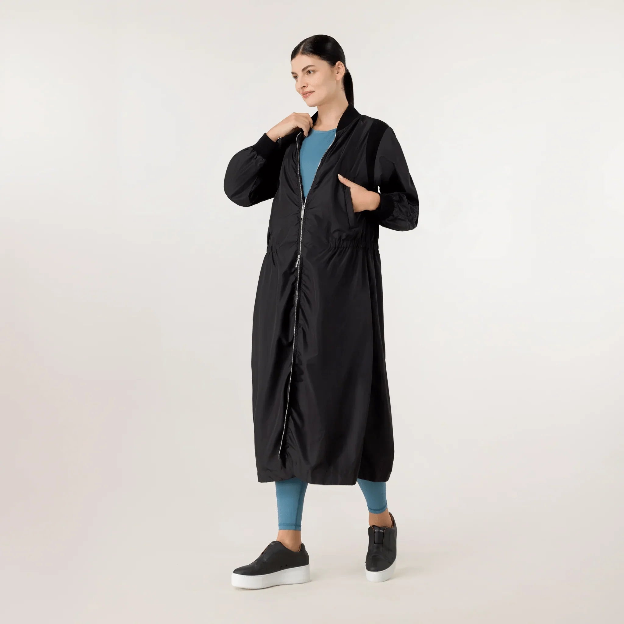 A model wearing seasonal black bomber parka with pockets - عارضة أزياء ترتدي سترة سوداء مزودة بجيوب وسحاب