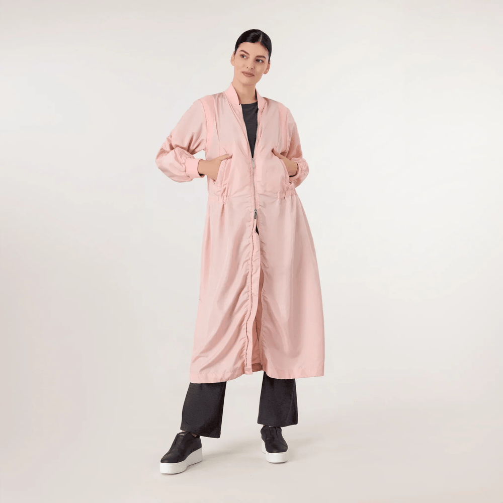 A model wearing seasonal pink bomber parka with pockets - عارضة أزياء ترتدي سترة وردية اللون مزودة بجيوب وسحاب