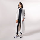 ِA model wearing a stone-colored pleated abaya - عارضة أزياء ترتدي عباية بلون حجري