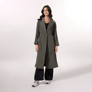 A model wearing an olive trench coat with a fluid silhouette & tie waist - عارضة أزياء ترتدي معطف ترينش باللون زيتوني بقصّة انسيابية وحزام ربط على الخصر