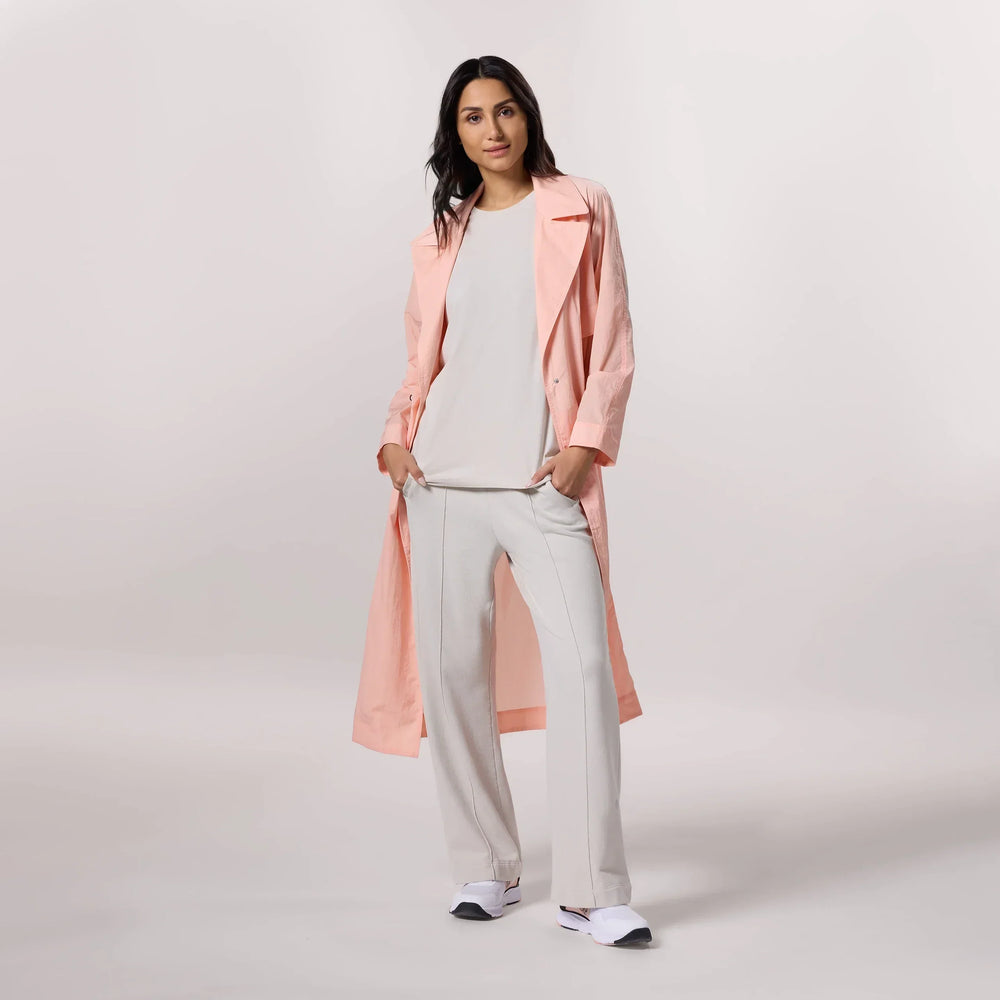 A model wearing a seasonal pink lightweight trench coat - عارضة أزياء ترتدي معطف وردي خفيف الوزن