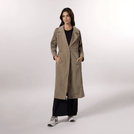A model wearing a lightweight sand trench coat with a relaxed seasonal fit - عارضة أزياء ترتدي معطف ترينش خفيف الوزن باللون الرملي وقصّة موسمية مريحة