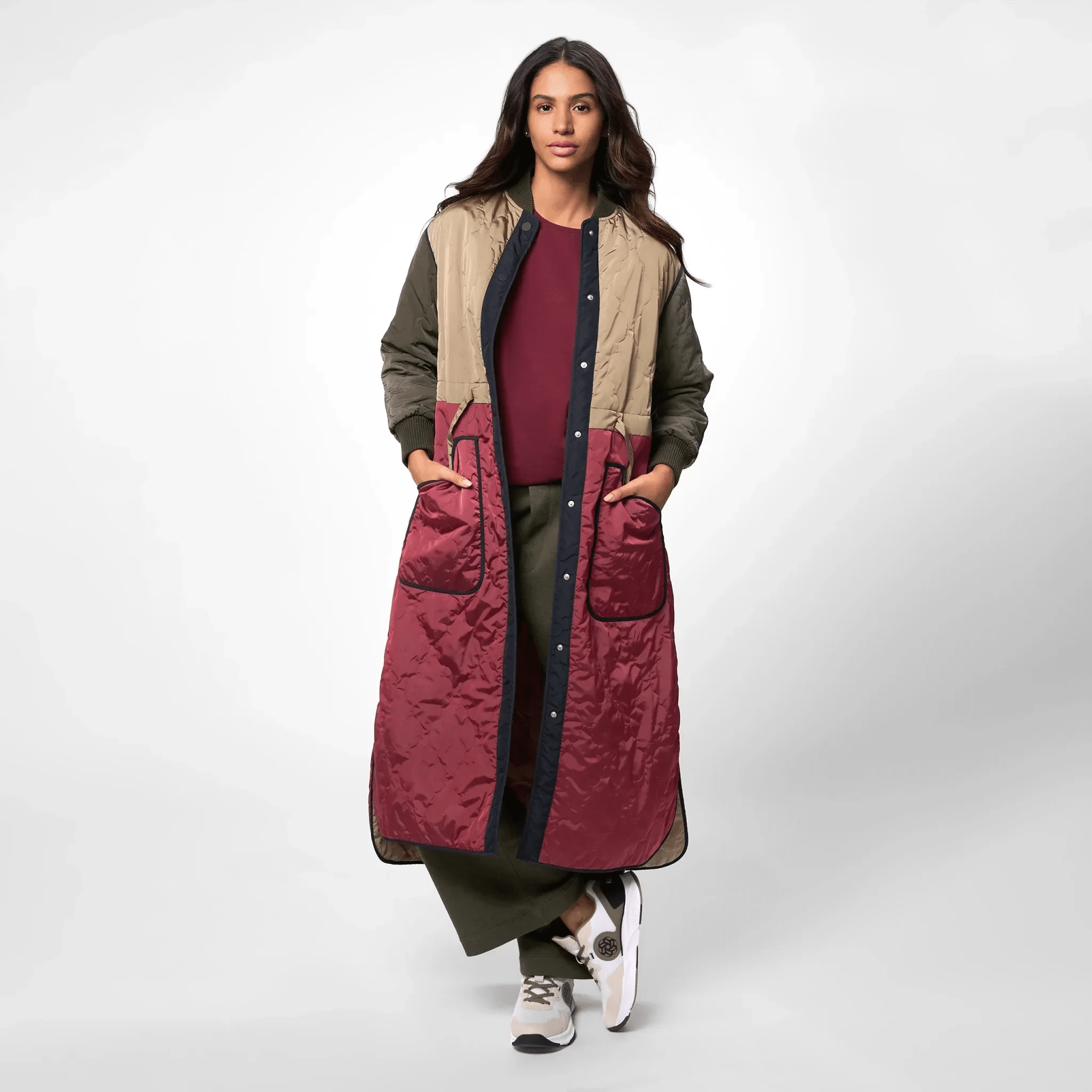 A model wearing a multicolor quilted maxi coat with side pockets - عارضة أزياء ترتدي معطف ماكسي مبطن متعدد الألوان مع جيوب جانبية