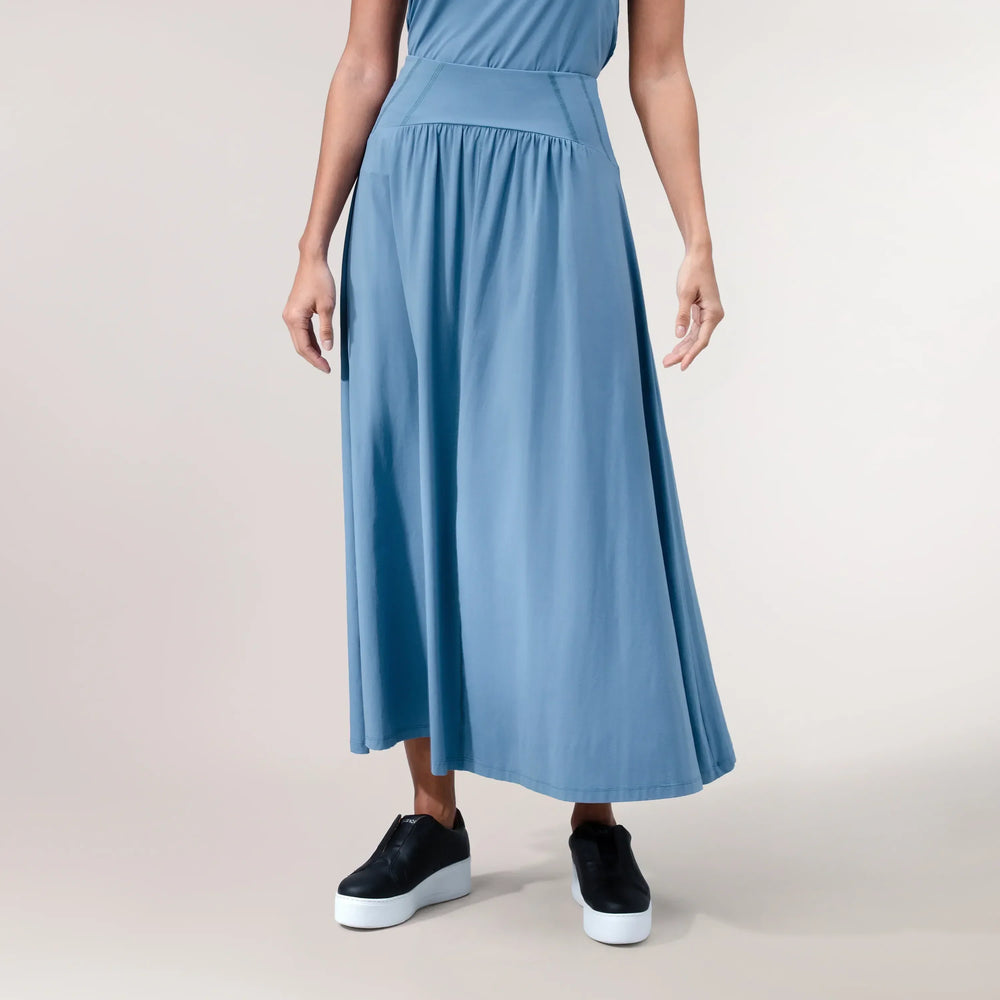 A model wearing a blue "Flow" jersey skirt with a sporty cut - عارضة أزياء ترتدي تنورة "فلو" من قماش الجيرسي باللون الأزرق وبقصّة رياضية