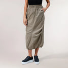 A model wearing a seasonal beige parachute skirt with pockets & elastic waistband - عارضة أزياء ترتدي تنورة باراشوت بيج مع جيوب وحزام مطاطي
