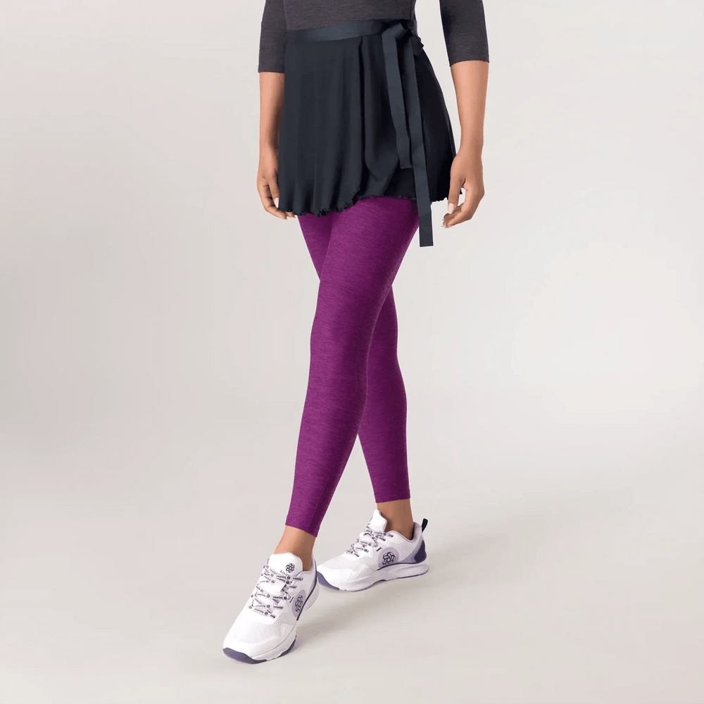 A model wearing a black Studio Practice skirt over purple pants - عارضة أزياء ترتدي تنورة سوداء من "ستوديو براكتس" كوليكشن فوق بنطال أرجواني