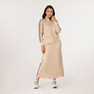 A model wearing a seasonal sand midi track skirt set with striped ines - عارضة أزياء ترتدي تنورة رياضية متوسطة الطول باللون الرملي ذات خطوط جانبية