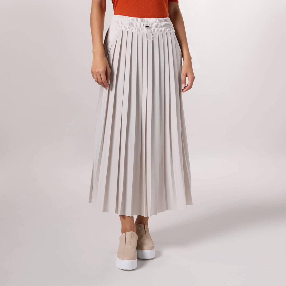 A model wearing stone colored active pleated skirt - عارضة أزياء ترتدي تنورة رياضية بطيات باللون الحجري