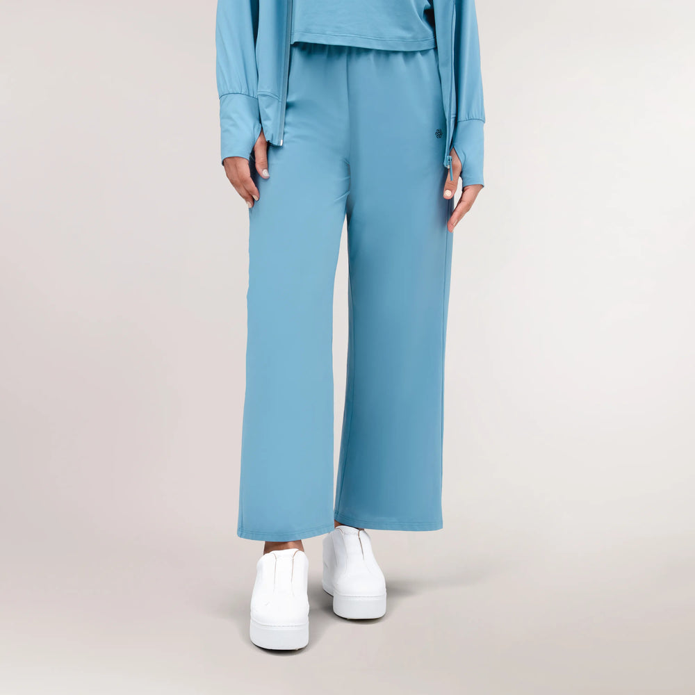 A model wearing core blue "Flow" lounge pants - عارضة أزياء ترتدي بنطال لوْنج "فلو" باللون الأزرق