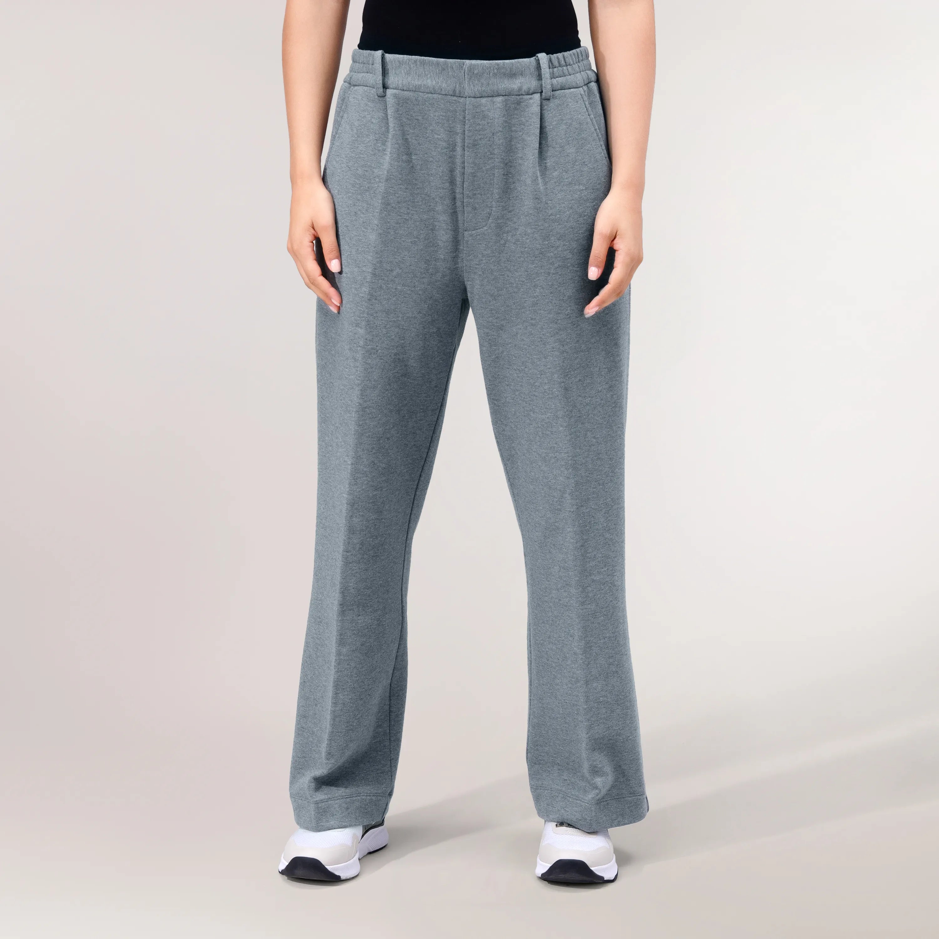 A model wearing a seasonal grey melange flare track pants - عارضة أزياء ترتدي بنطال رياضي واسع باللون الرمادي الميلانج