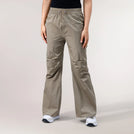 Beige parachute pants with adjustable cuffs with a lightweight drape - بنطال باراشوت بيج يتميز بحواف قابلة للتعديل وقماش خفيف ينسدل بنعومة