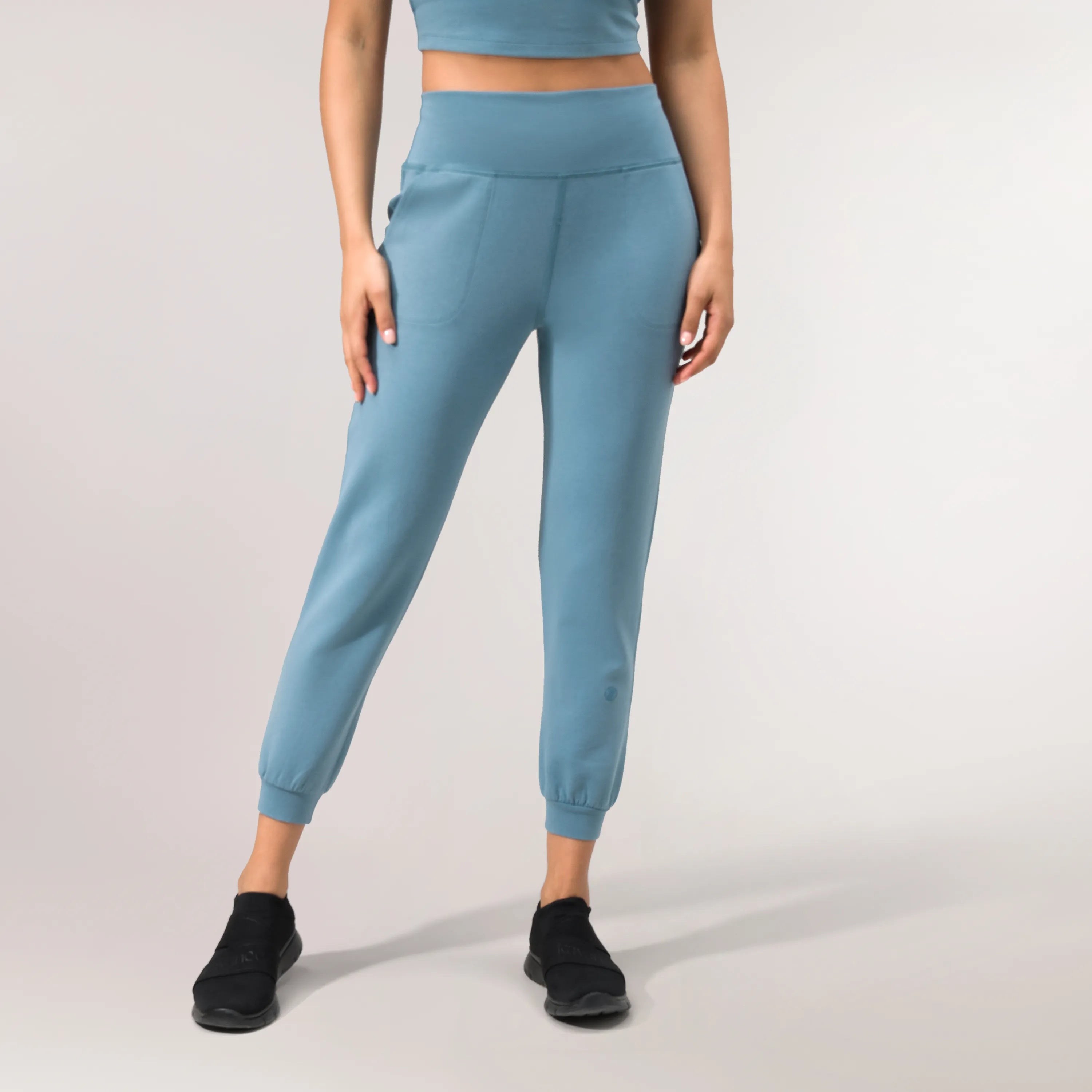 A model wearing a core blue walkabout jogger with pockets - عارضة أزياء ترتدي بنطال رياضي مع جيوب باللون الأزرق