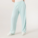 A model wearing a seasonal light blue velour track pants with side stripes - عارضة أزياء ترتدي بنطال رياضي باللون الأزرق فاتح مع خطوط جانبية