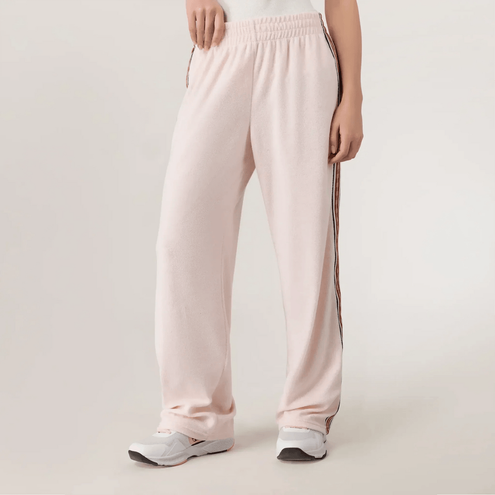 Pink velour track pants with wide leg & soft plush texture - عارضة أزياء ترتدي بنطال وردي واسع الأرجل