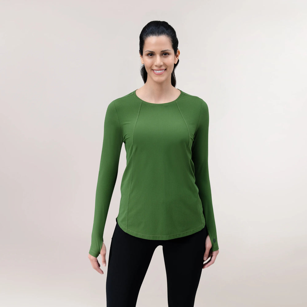 A model in a dark green Twirl top with long sleeves over black leggings - عارضة أزياء ترتدي بلوزة "تويرل" طويلة الأكمام باللون أخضر غامق مع ليقنز أسود